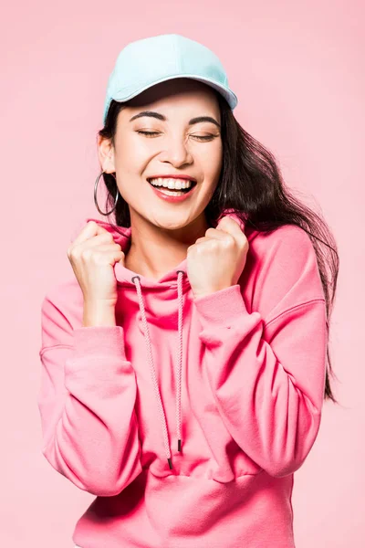 Привлекательная Азиатская Женщина Закрытыми Глазами Розовом Пуловере Кепка Улыбается Изолированы — стоковое фото