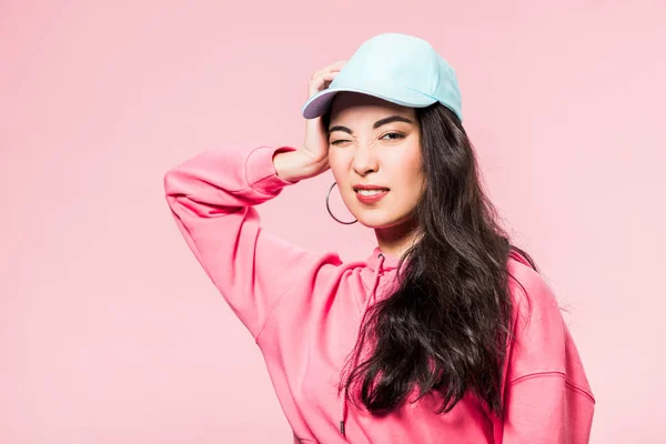 Aantrekkelijke Aziatische Vrouw Roze Pullover Cap Knipogen Geïsoleerd Roze — Stockfoto