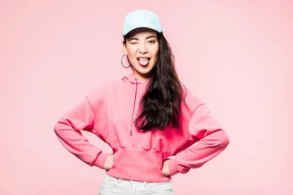 Aantrekkelijke Aziatische Vrouw Roze Pullover Cap Knipogen Steken Uit Tong — Stockfoto