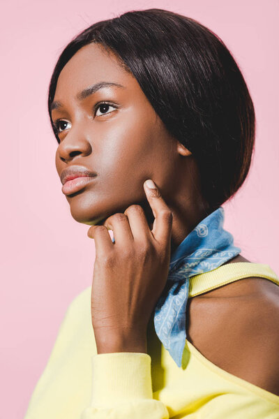 pensive african american woman in scarf looking away isolated on pink 