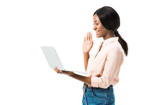 african american woman in shirt holding laptop and talking in video chat isolated on white 