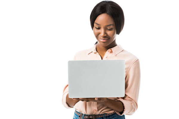 улыбающаяся африканская американка в футболке с ноутбуком, изолированным на белом
 