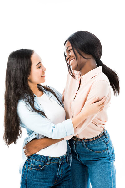 улыбающиеся азиатские и африканские американские друзья обнимаются изолированно на белом
 