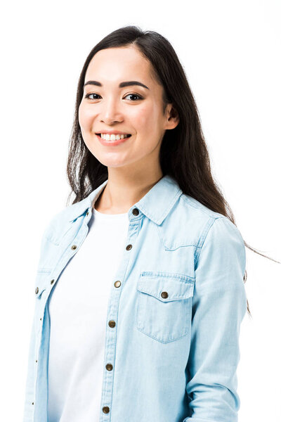 attractive and smiling asian woman in denim shirt looking at camera isolated on white 