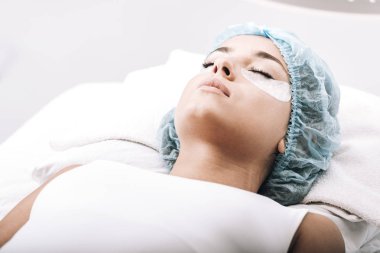 gri izole kanepede yatan sahte kirpikve kapalı gözleri ile model