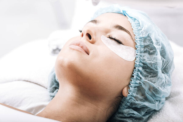 model with false eyelashes and closed eyes lying on couch