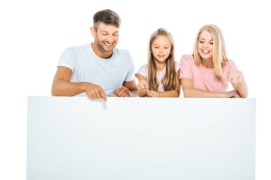 Mutlu ebeveynler ve kızlar beyaz üzerine izole edilmiş boş bir pankartı işaret ediyorlar. 