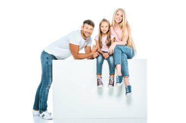 Mutlu anne ve kız kübün üzerinde oturan beyaz adamın yanında 