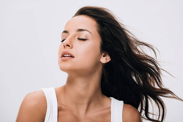 brunette beautiful woman with closed eyes and long healthy and shiny hair isolated on grey
