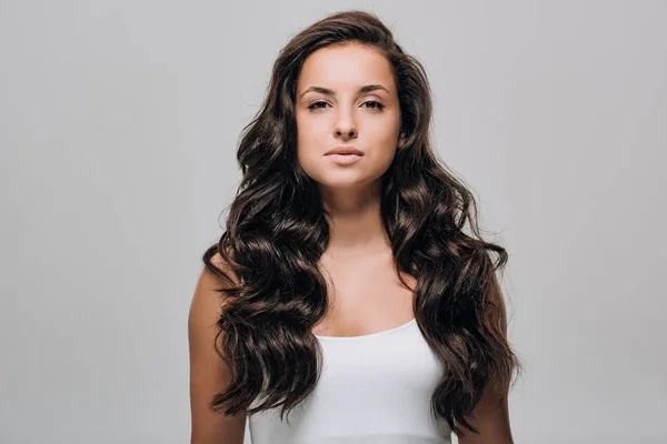 Brunette Mooie Vrouw Met Lange Krullend Gezond Haar Geïsoleerd Grijs — Stockfoto