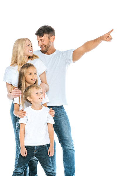 happy man looking at wife while pointing with finger near kids on white 
