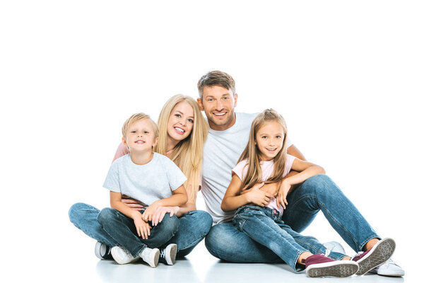 happy parents and kids in blue jeans sitting on white 