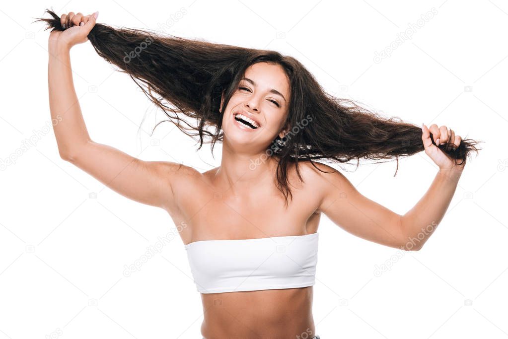 happy brunette beautiful woman holding wavy hair isolated on white
