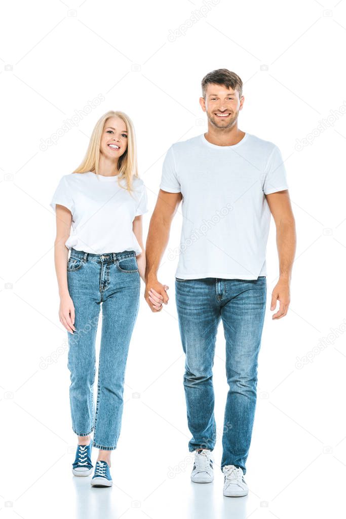happy man and woman holding hands and walking on white