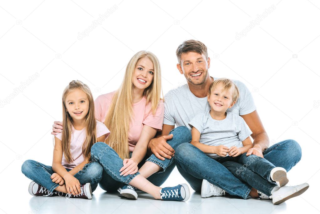 Cheerful kids sitting with happy parents on white