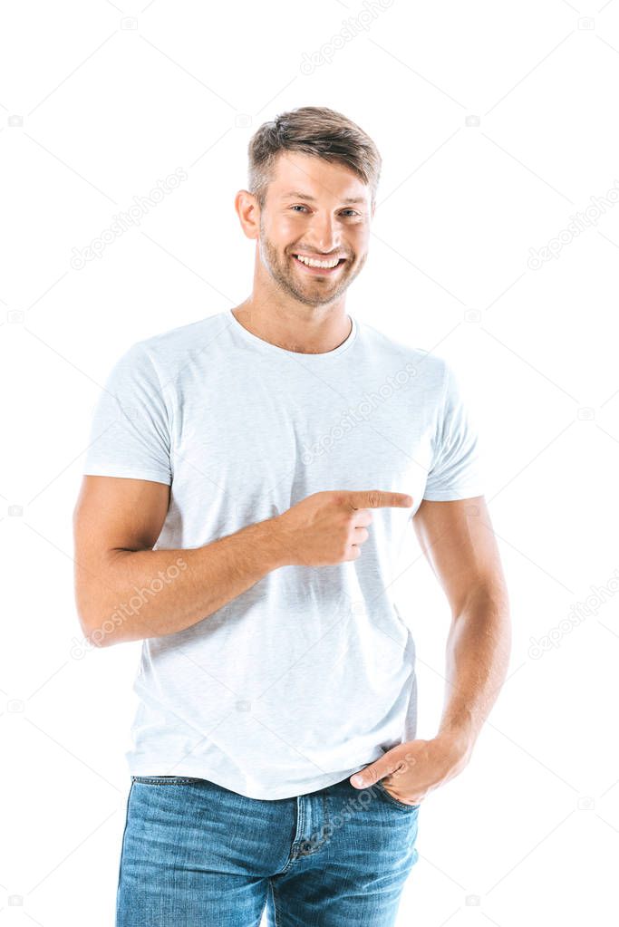 happy man standing with hand in pocket and pointing with finger isolated on white 