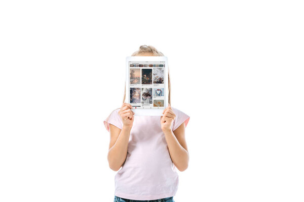 KYIV, UKRAINE - AUGUST 19, 2019: kid covering face while holding digital tablet with pinterest app on screen isolated on white 