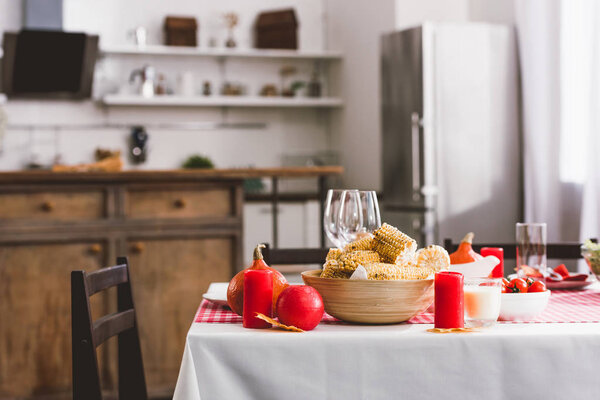 стол с кукурузой, стаканами, свечами и пирожками в день рождения
 