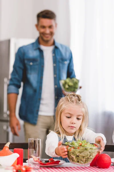 Selectieve Focus Van Leuke Dochter Zetten Tafel Kom Met Salade — Stockfoto