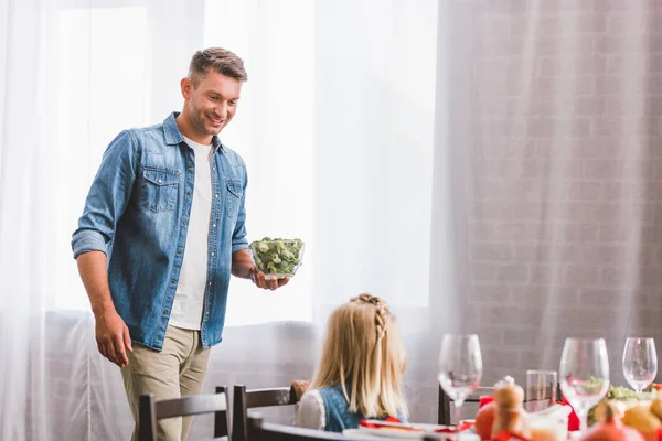 Sonriente Padre Sosteniendo Tazón Con Brócoli Mirando Linda Hija Día — Foto de Stock