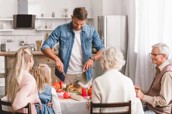 Miembros Familia Sentados Mesa Padre Cortando Sabroso Pavo Día Acción — Foto de Stock