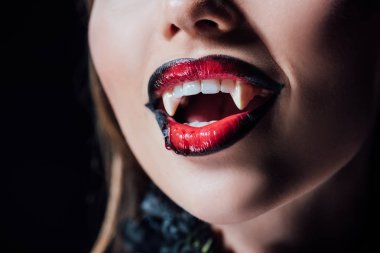 close up view of scary vampire girl with fangs isolated on black clipart