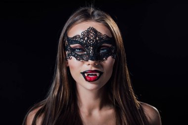 naked scary vampire girl in masquerade mask showing fangs isolated on black clipart
