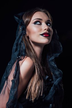 Siyah gotik elbiseli ve duvak takmış gülümseyen vampir kız.