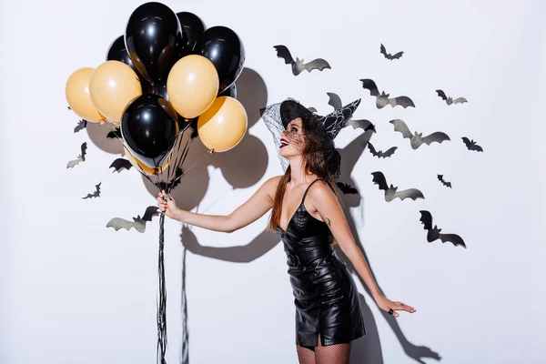 Glückliches Mädchen Schwarzem Hexenhalloween Kostüm Mit Luftballons Nahe Weißer Wand — Stockfoto