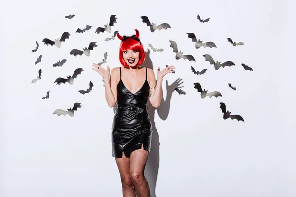 Ragazza Costume Diavolo Halloween Vicino Muro Bianco Con Pipistrelli Decorativi — Foto Stock