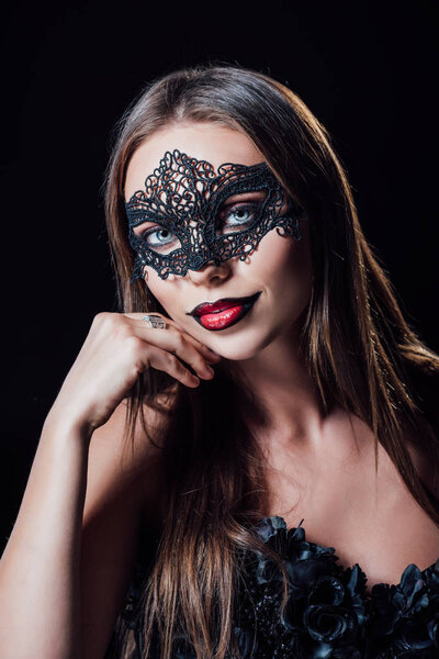 scary vampire girl in black gothic dress and mask isolated on black