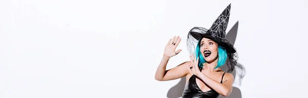 panoramic shot of girl in black witch Halloween costume with blue hair on white background