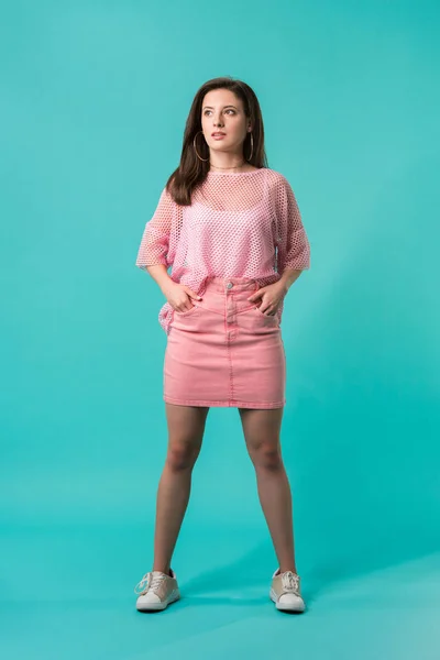Girl Pink Outfit Standing Hands Hips Looking Away Turquoise Background — Stock Photo, Image