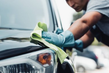 selective focus of car cleaner wiping capote with rag clipart