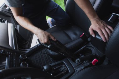 Arabanın içini süpüren araba temizleyicisinin kırpılmış görüntüsü 