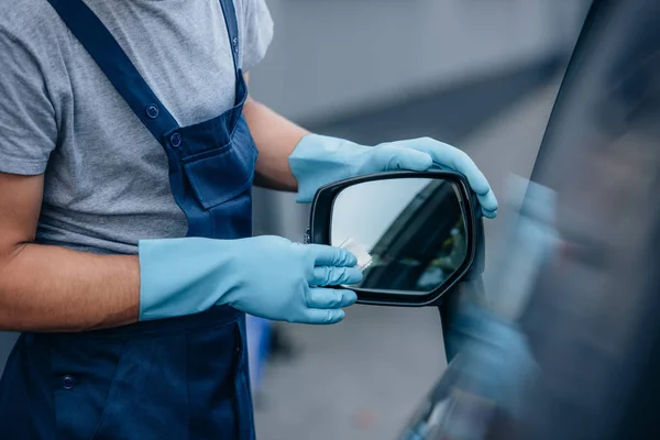 汽车清洁剂擦拭侧镜的裁剪视图 — 图库照片