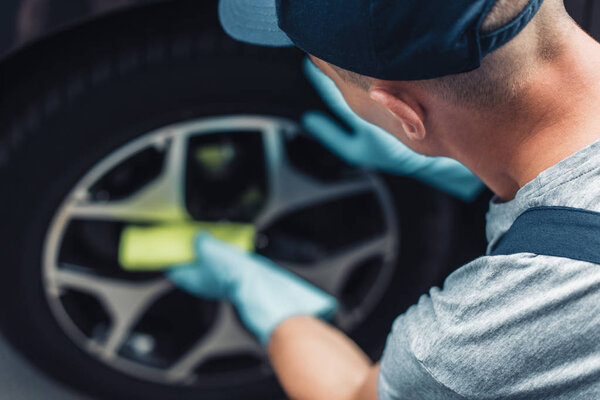 selective focus of car cleaner wiping wheel with rag