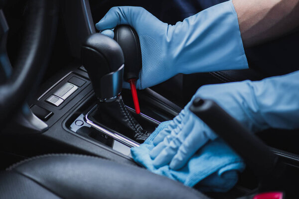 обрезанный вид на очиститель автомобиля пыли переключатель передач с резиновым воздухом ниже и тряпки
