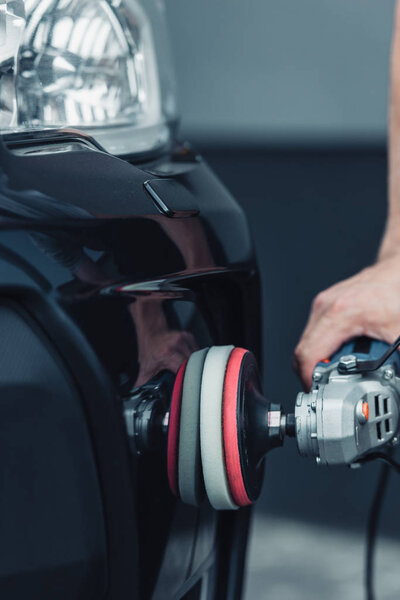 обрезанный вид автомобиля чистящего средства полировки с буферной машиной
