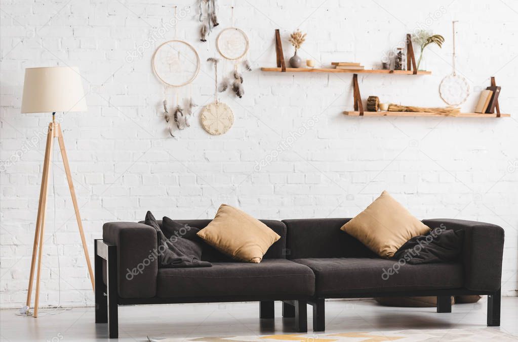 interior of cozy living room with sofa, lamp and dream catchers on wall