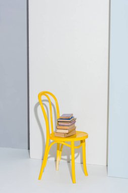Beyaz ve gri kitaplı sarı koltuk 