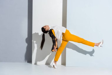 Gri ve beyaz üzerinde duran kızın yan görünüşü 