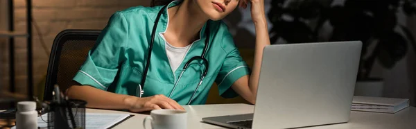 Panoramisch Shot Van Vermoeide Verpleegster Uniform Zittend Aan Tafel Tijdens — Stockfoto