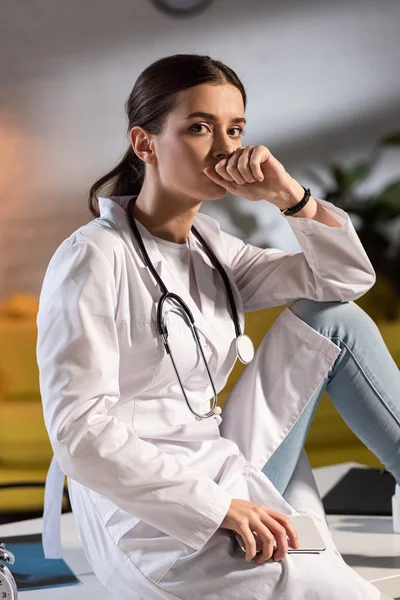 Attraente Medico Camice Bianco Con Stetoscopio Che Tiene Smartphone Durante — Foto Stock