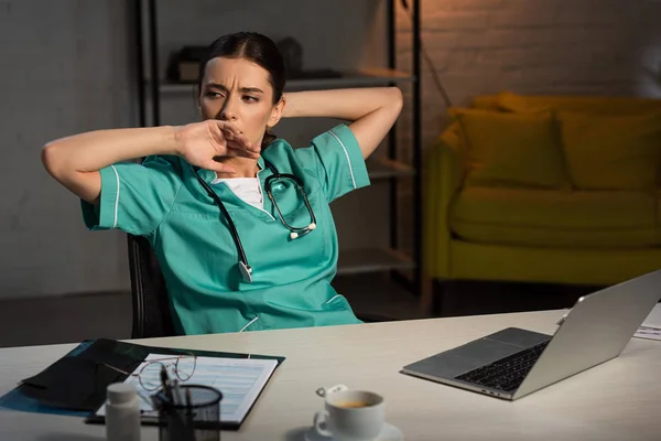 Enfermeira Atraente Uniforme Sentado Mesa Bocejando Durante Turno Noite — Fotografia de Stock