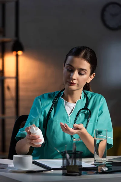 Enfermera Atractiva Uniforme Sentada Mesa Tomando Píldora Durante Turno Noche — Foto de Stock