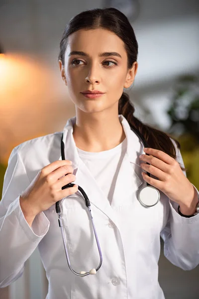 夜勤時に聴診器を持つ白衣の魅力的な医者 — ストック写真