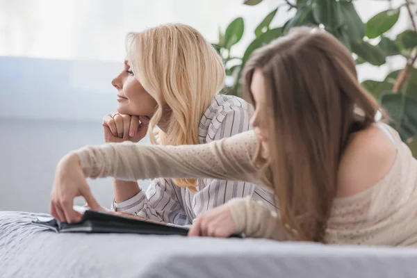 Nachdenkliche Frau Schaut Weg Während Sie Neben Tochter Auf Dem — Stockfoto