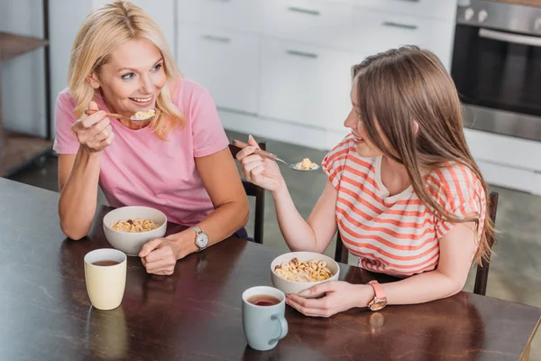 Alegre Madre Hija Hablando Mientras Están Sentadas Mesa Cocina Desayunando —  Fotos de Stock