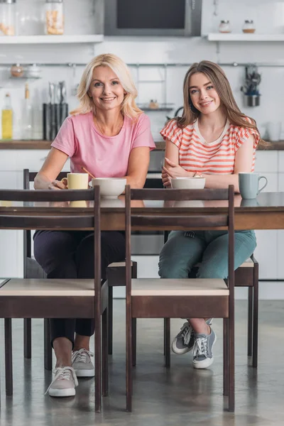 Smiling Mother Daughter Looking Camera While Sitting Kitchen Table Having — Stock Photo, Image
